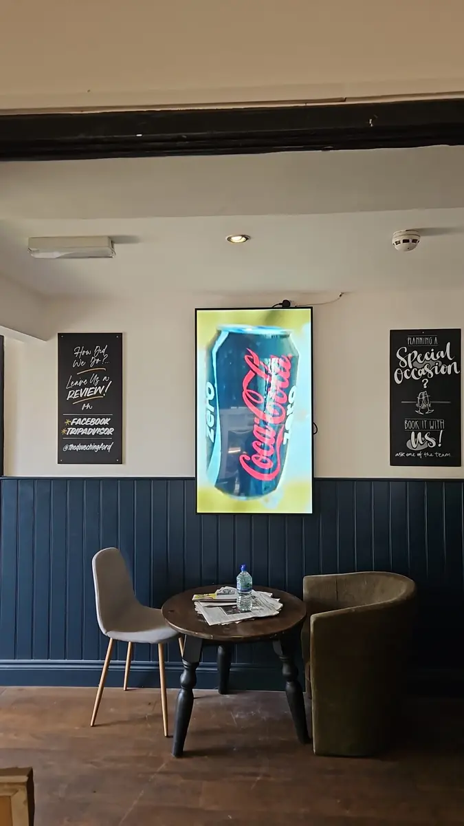 Digital signage in a pub bar area promoting drinks offers.