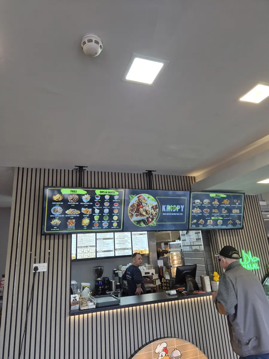 Twin digital menu screens in a UK restaurant entrance welcoming diners.