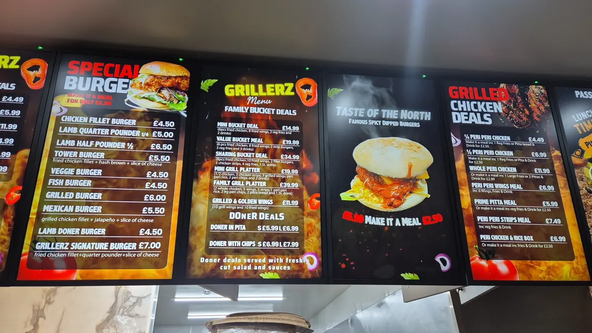 Digital menu screen in a takeaway displaying burgers and meal deals.