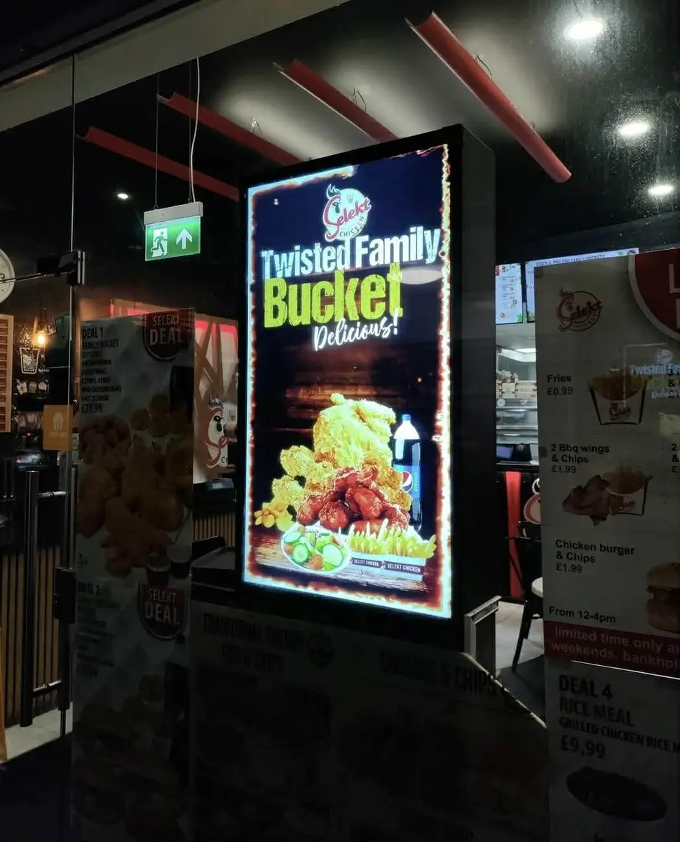 Window-facing digital screen in a takeaway attracting walk-in customers.